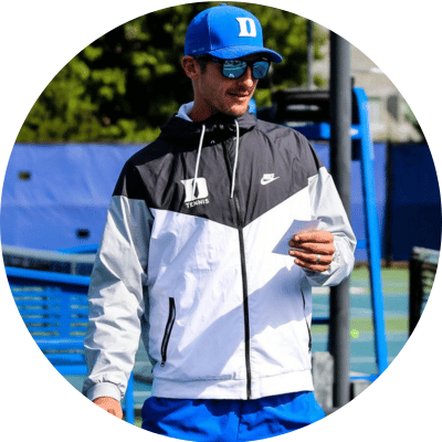 Photo of Maciel Sykut, Duke University associate head coach, wearing Duke hat and jacket