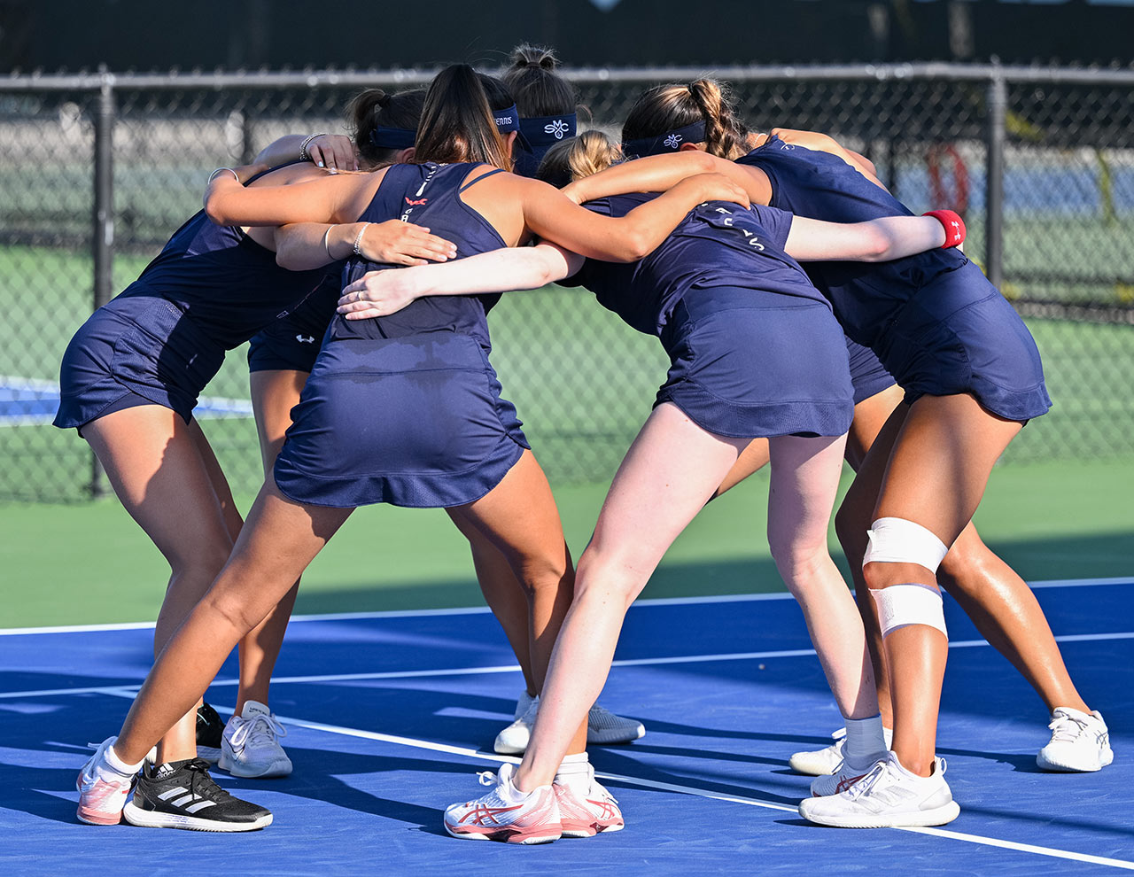 St. Mary's college tennis players huddle at 2024 NIT Championship by UTR Sports