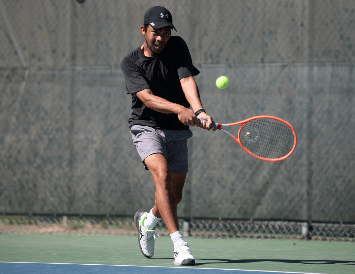 Photo of male tennis player hitting backhand during a Universal Tennis matchup