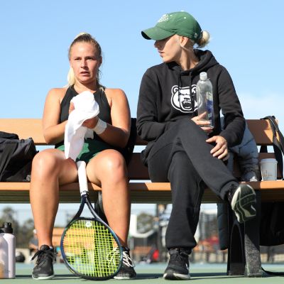 Hannah Keeling coaches a Georgia Gwinnett College player during a college tennis match, which Universal Tennis supports
