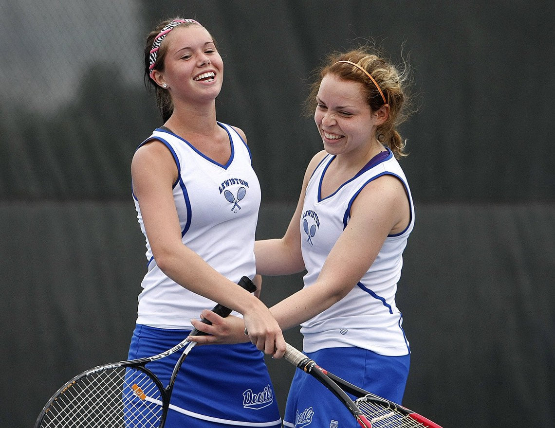 Girls playing high school tennis. Universal Tennis helps high school tennis teams earn revenue.