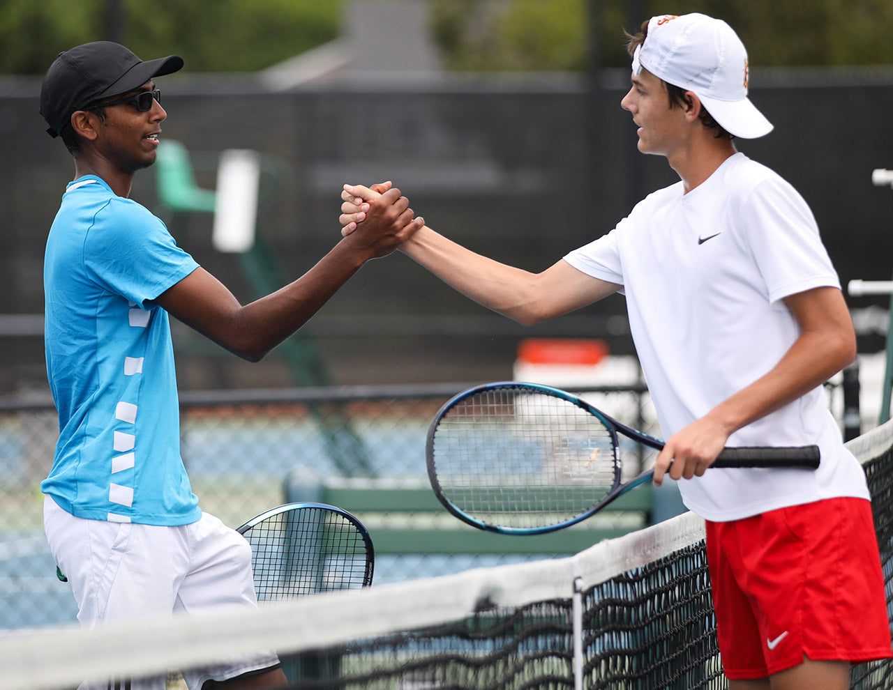 Junior tennis players high five at the net during a UTR Sports junior tennis matchup while improving their UTR Ratings