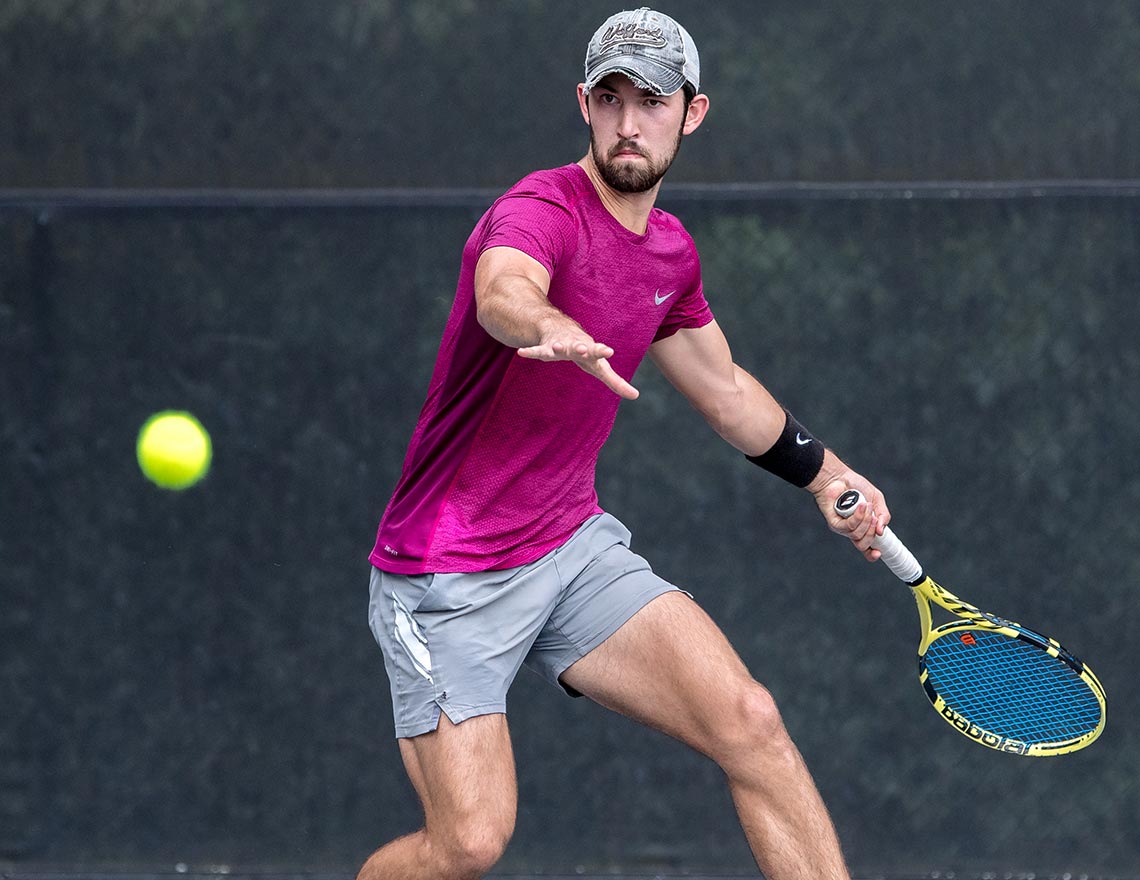 Photo of a man hitting a left-handed forehand while playing a Universal Tennis event with a Universal Tennis provider